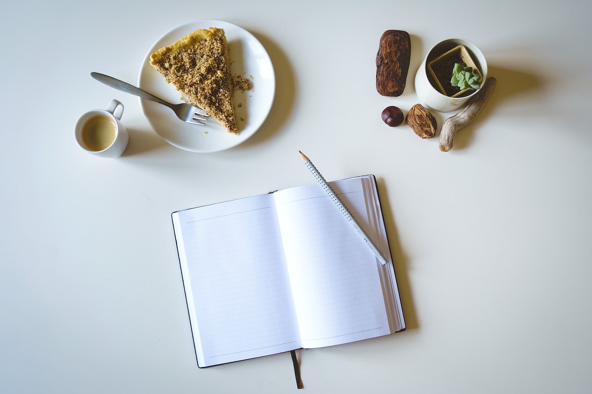 Writing a journal while having cake and coffee