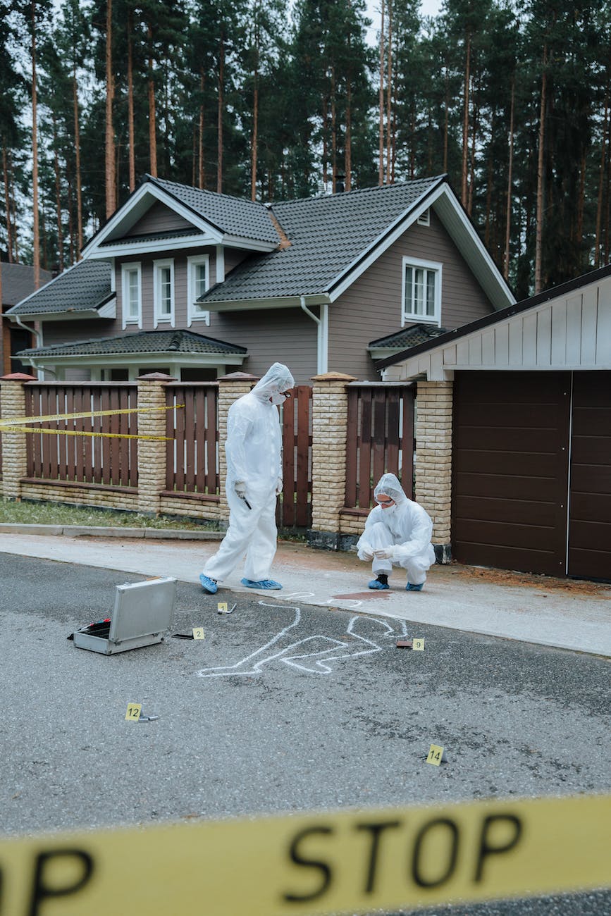 people wearing personal protective equipment standing in the crime scene